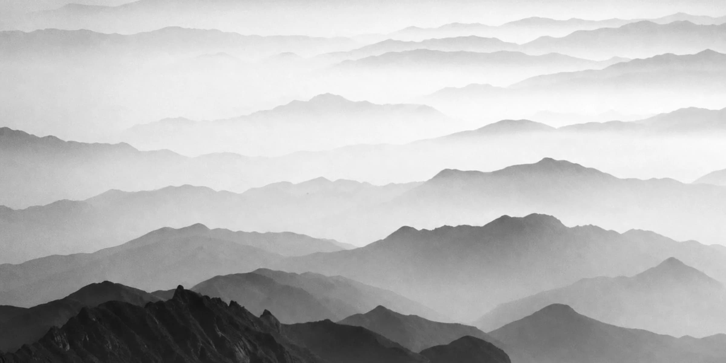 Mountain ridgelines dissolving into fog, ridge by ridge